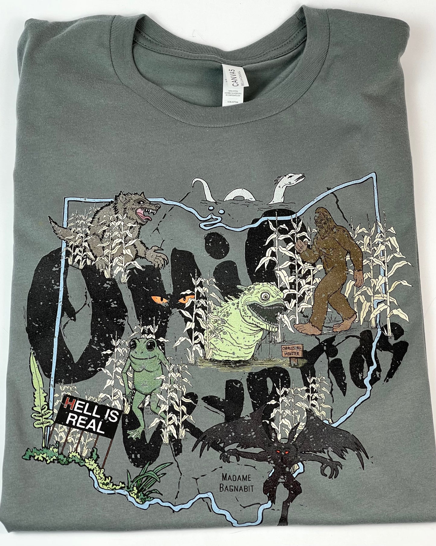 Gray blue t-shirt with a graphic design of various creatures and text on a white background