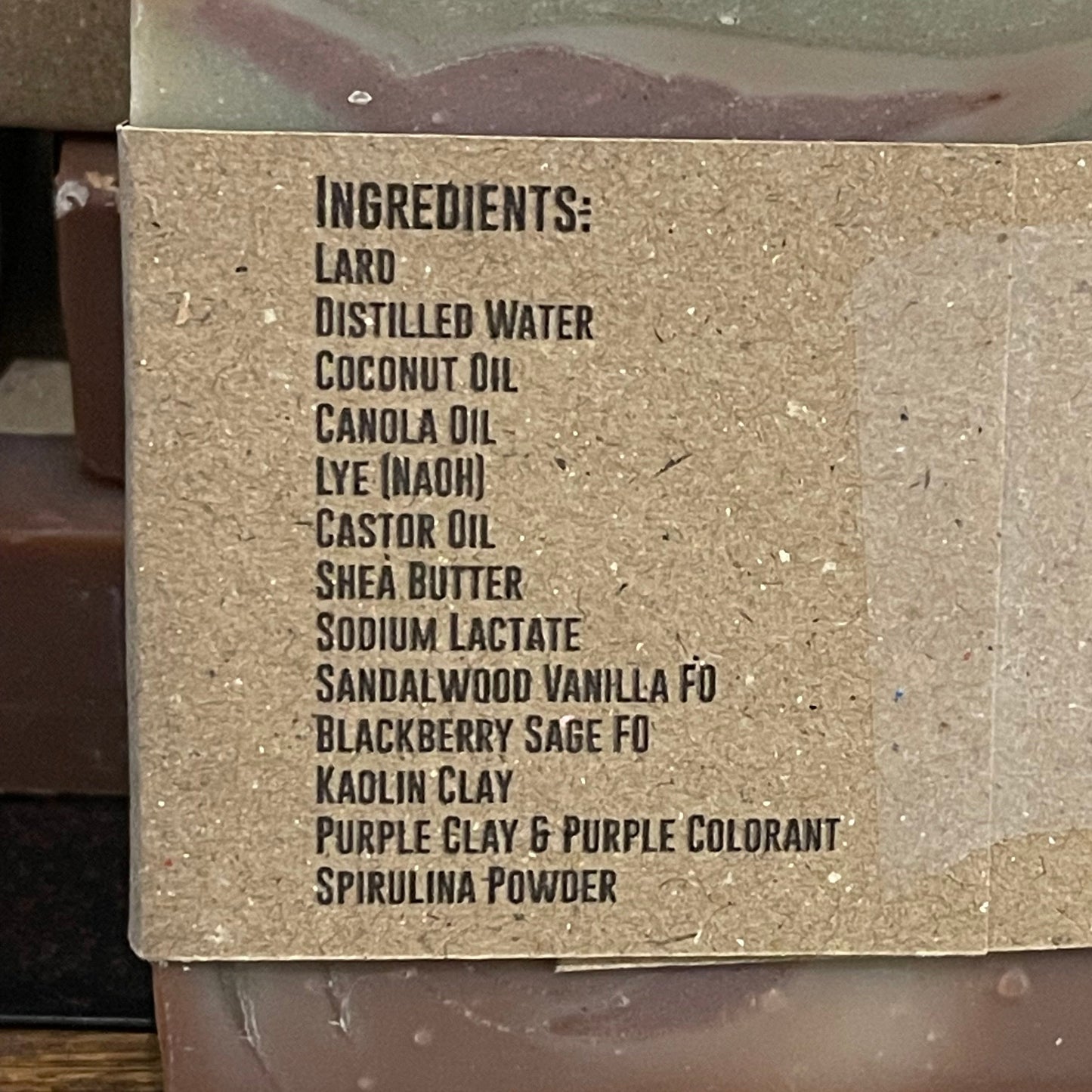 Bar of soap with visible ingredient list on a wooden surface