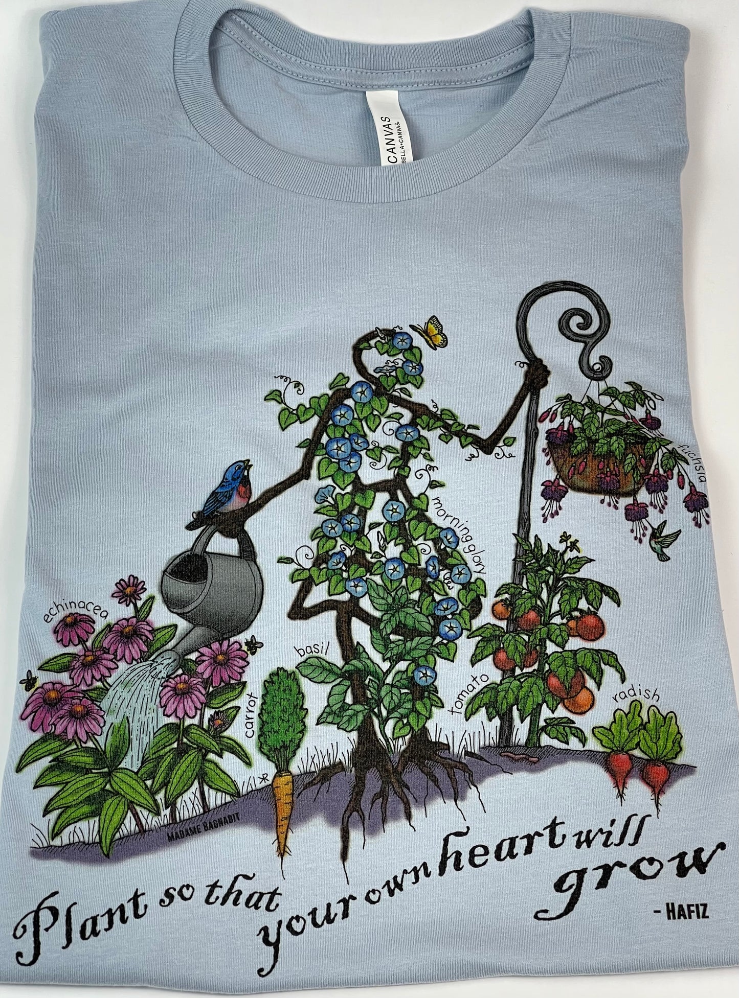 Light blue t-shirt with garden-themed design and text on a white background