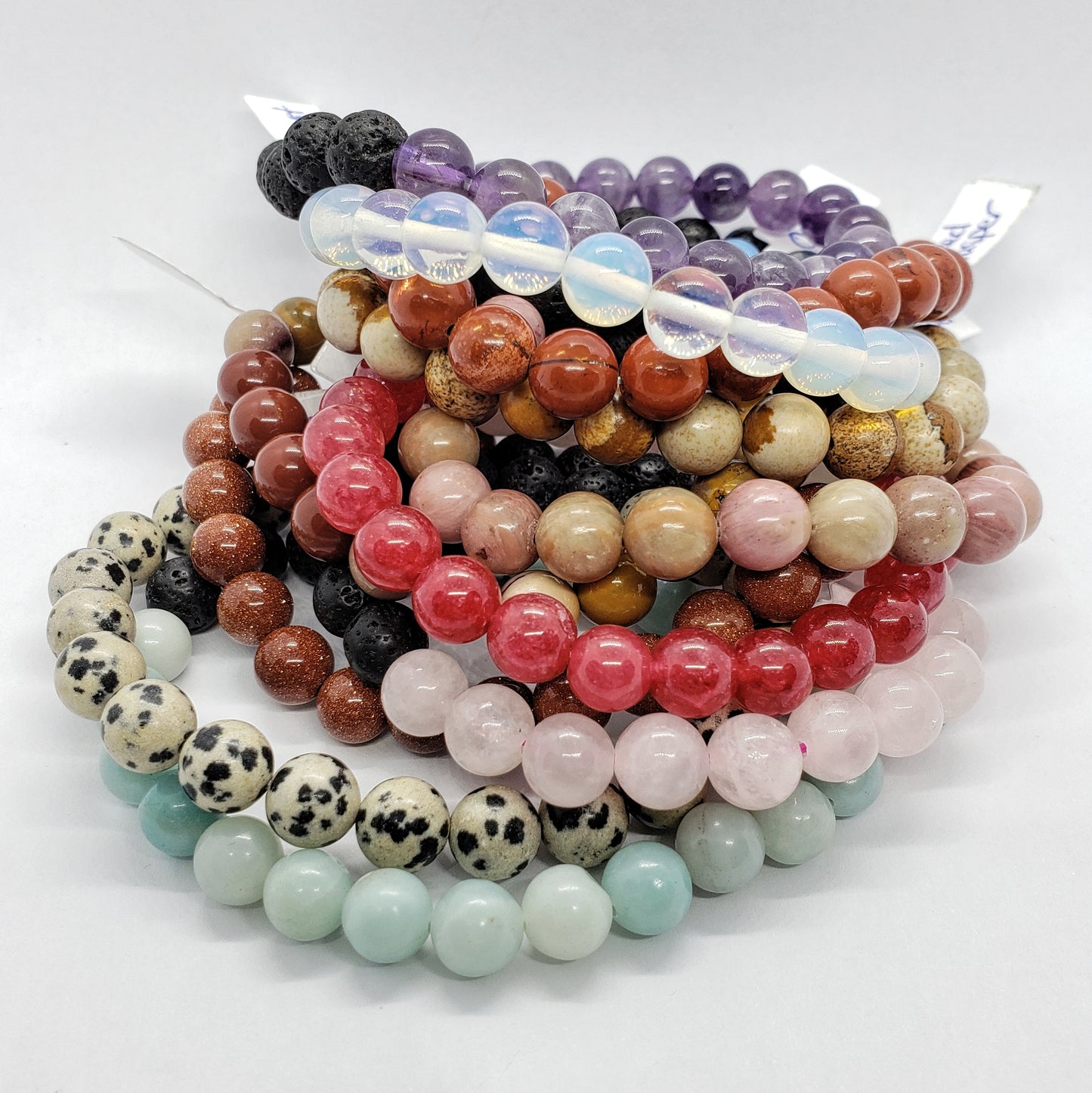 Stack of colorful beaded bracelets on a white background