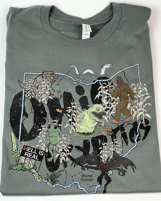 Gray blue t-shirt with a graphic design of various creatures and text on a white background