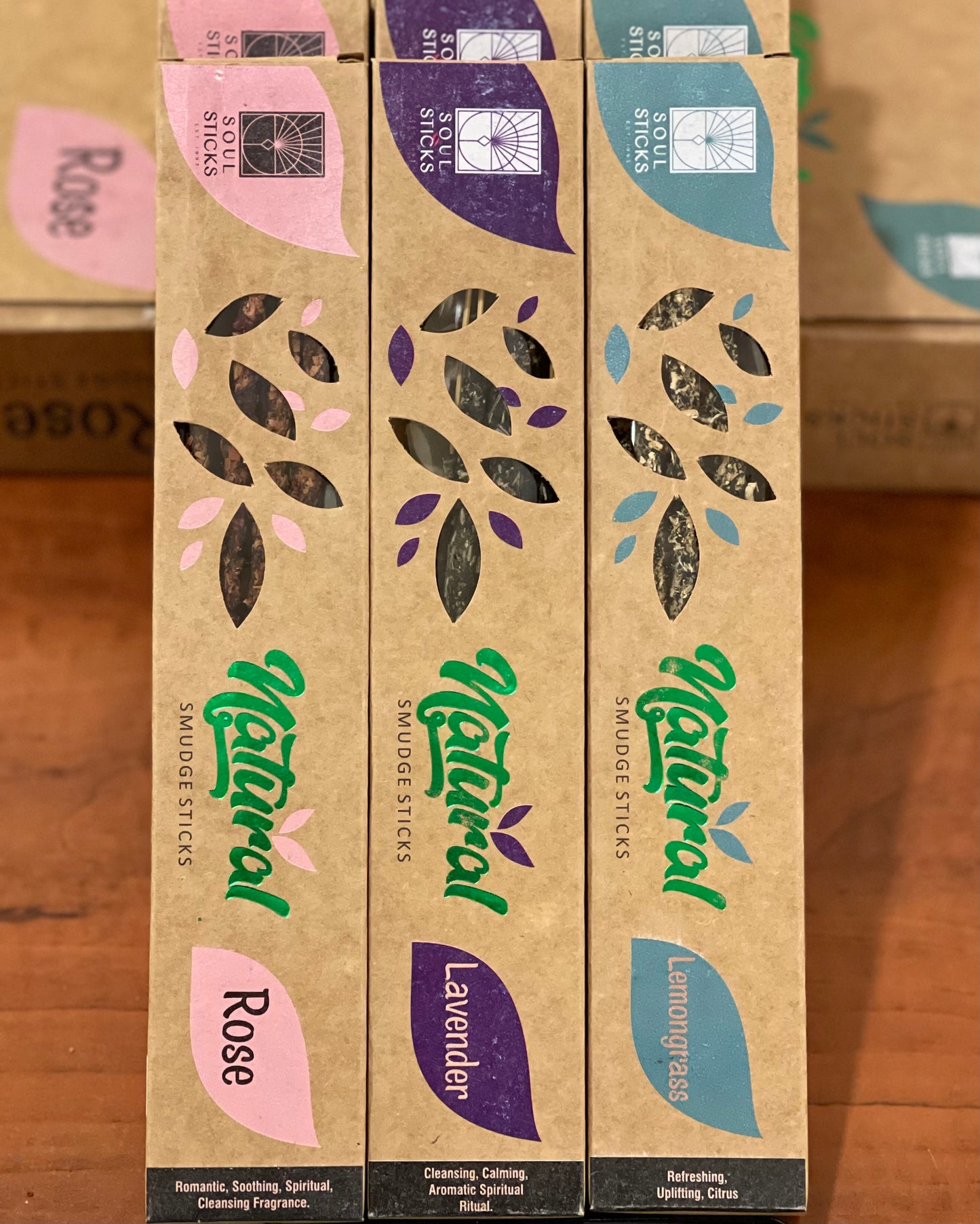 Three boxes of Faire's 15-gram Natural Herb Incense Sticks from India are arranged vertically, each showcasing a distinct scent: Rose, Lavender, and Lemongrass. The brown packaging features colored accents that match the scents and includes leafy cutouts offering a glimpse of the sticks inside.