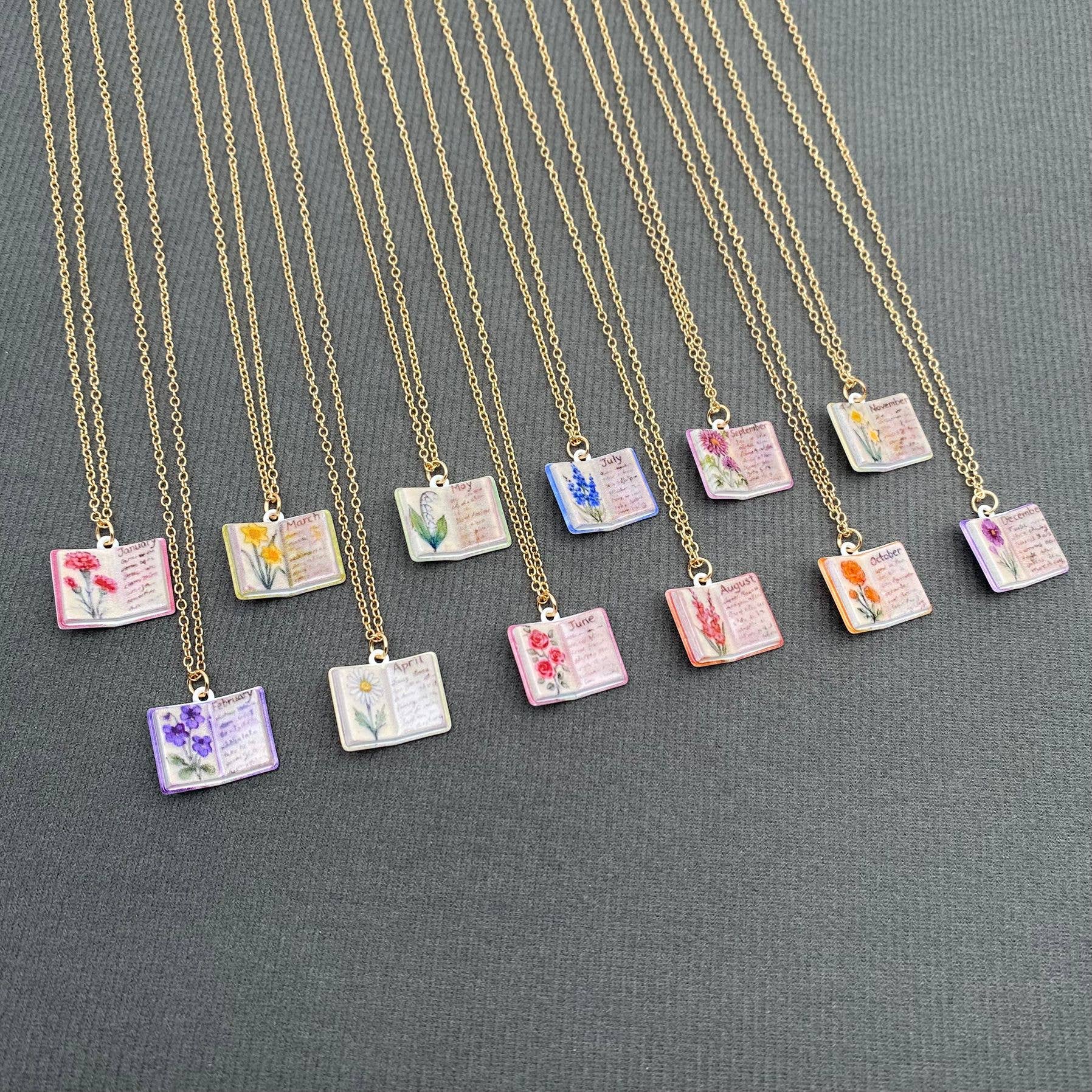 Necklaces with small pendant books on a gray background