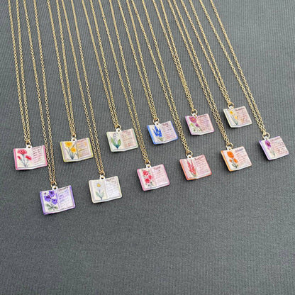 Necklaces with small pendant books on a gray background