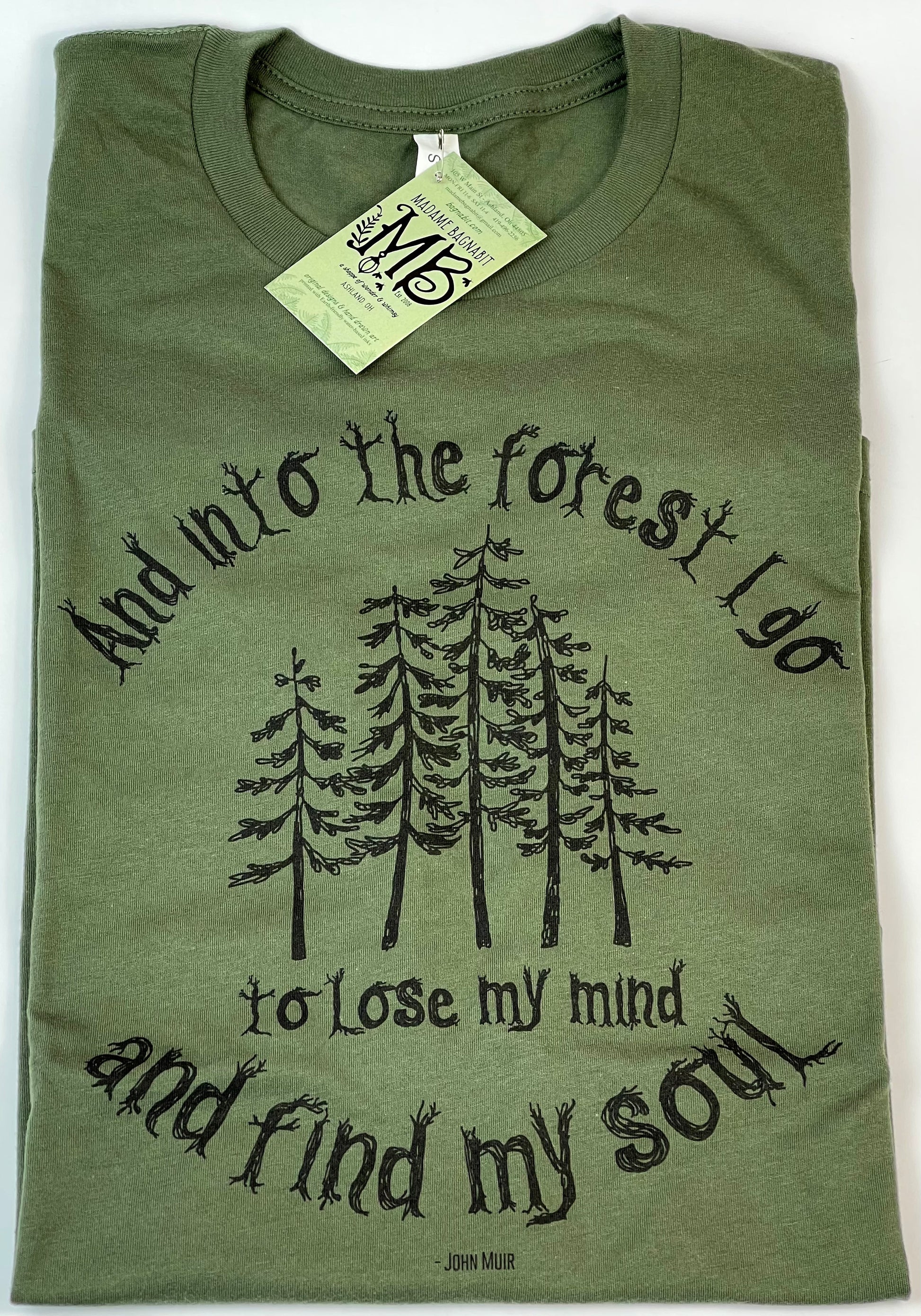 Green t-shirt with forest graphic and text on a white background