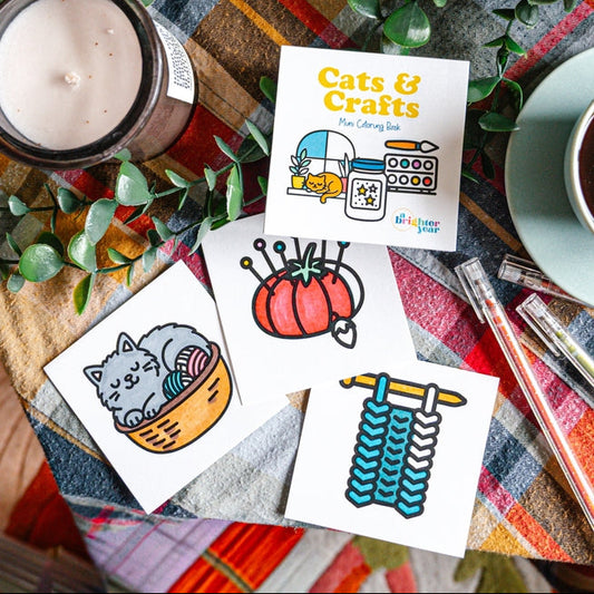 Cats & Crafts card with cat-themed illustrations on a colorful surface with a candle and plant.