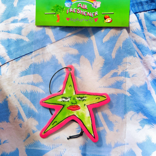 Star-shaped air freshener with a colorful label on a blue palm tree patterned background