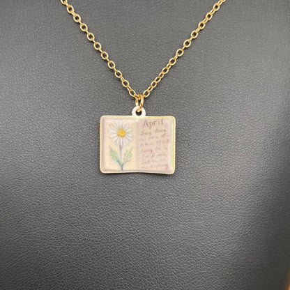 Necklace with a pendant featuring a daisy and text on a gray background