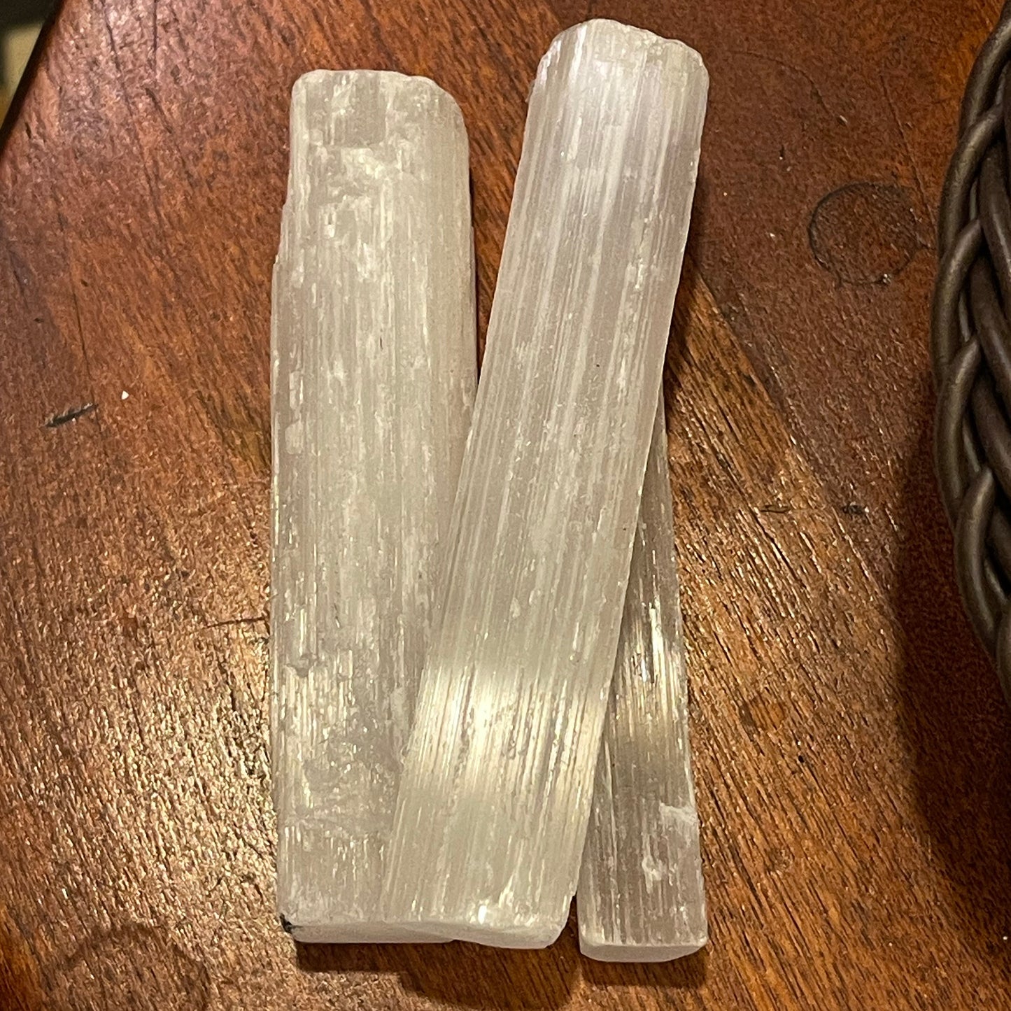 Three crystal sticks on a wooden surface