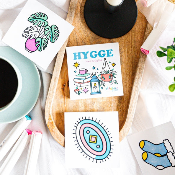 Colorful cards with illustrations on a wooden tray with a candle