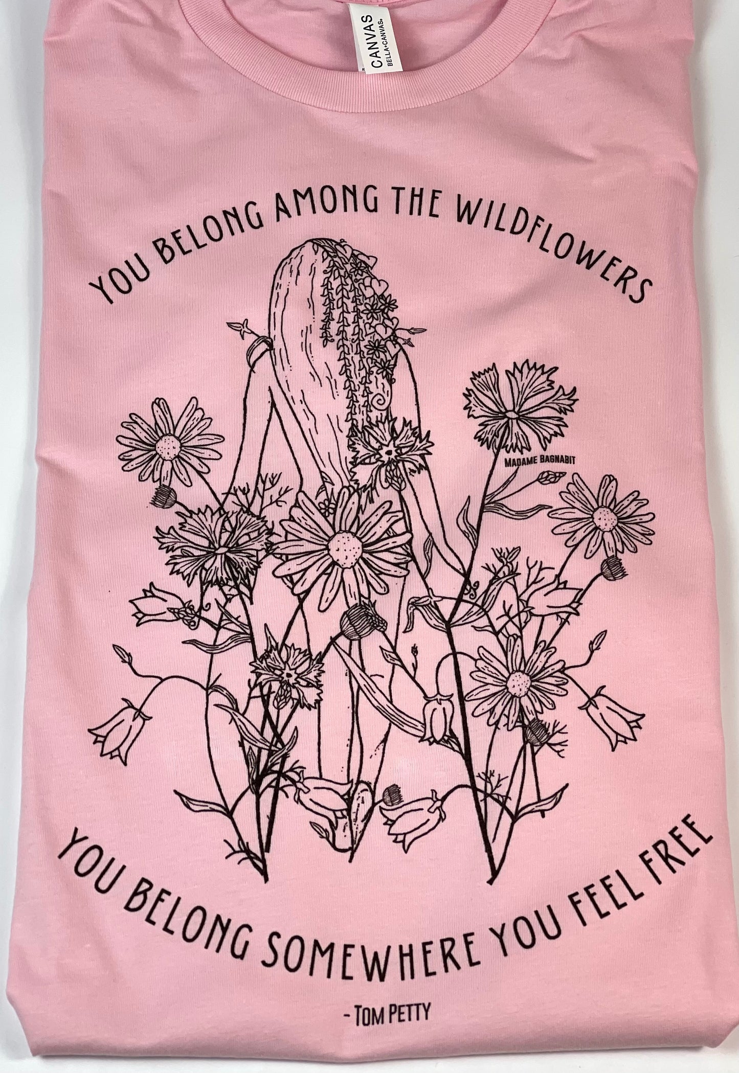 Pink t-shirt with black floral and cactus design and text on a white background