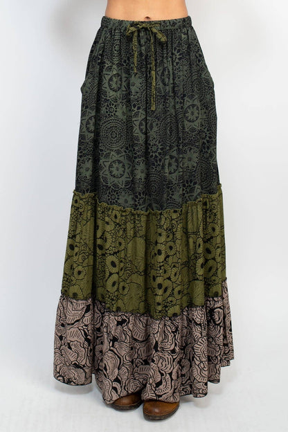 Long patterned skirt with a mix of green, brown, and black on a white background