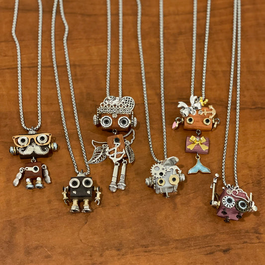 Collection of unique necklaces with various robot pendants on a wooden surface