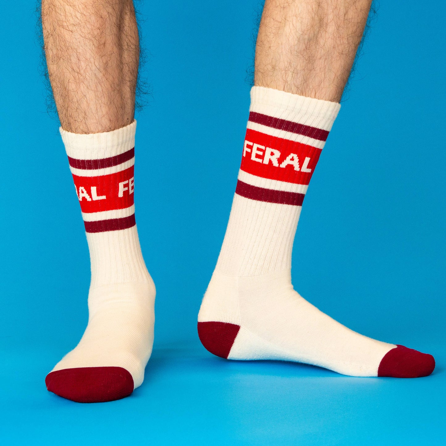 White socks with red and maroon stripes and text on a blue background