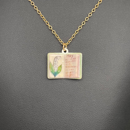 Necklace with a pendant featuring a flower and text on a gray background